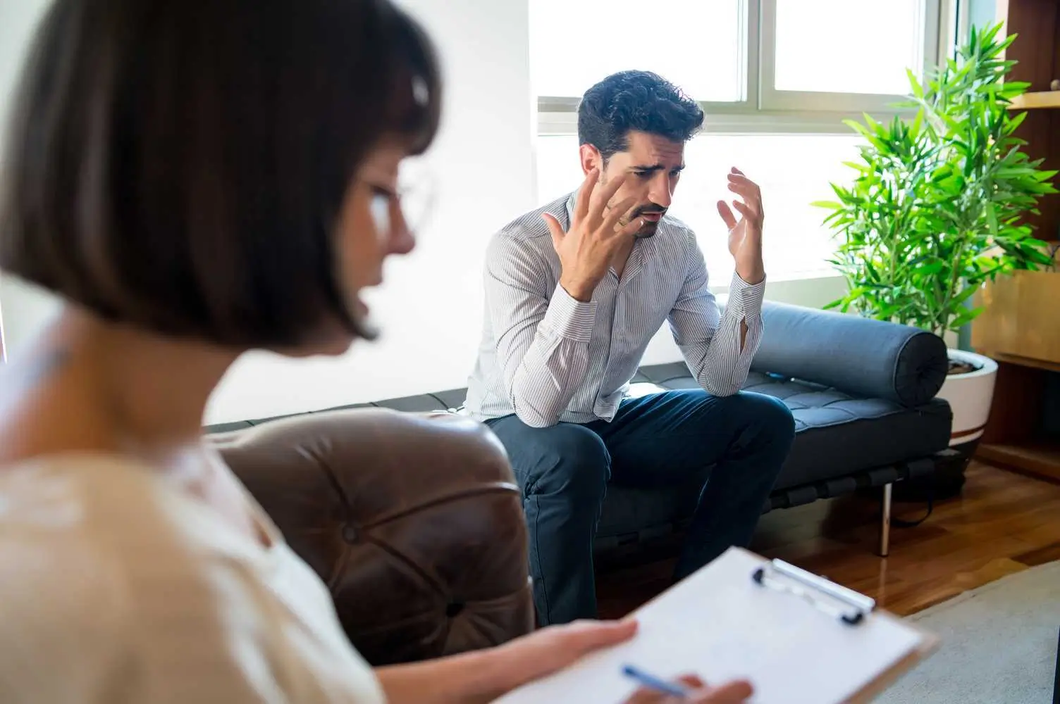 Man discussing distressing experiences with a therapist during an EMDR therapy session