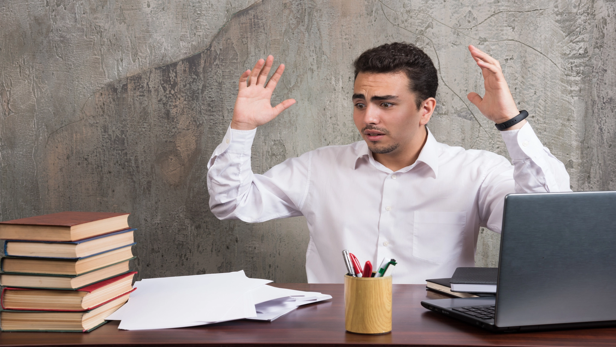 Overwhelmed employee struggling to start work at a desk