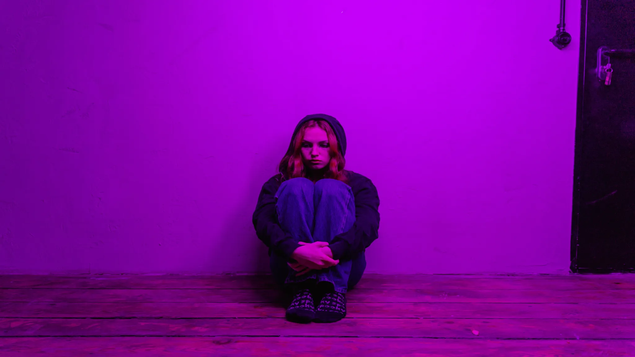 a girl sitting in a dark room experiencing agoraphobia